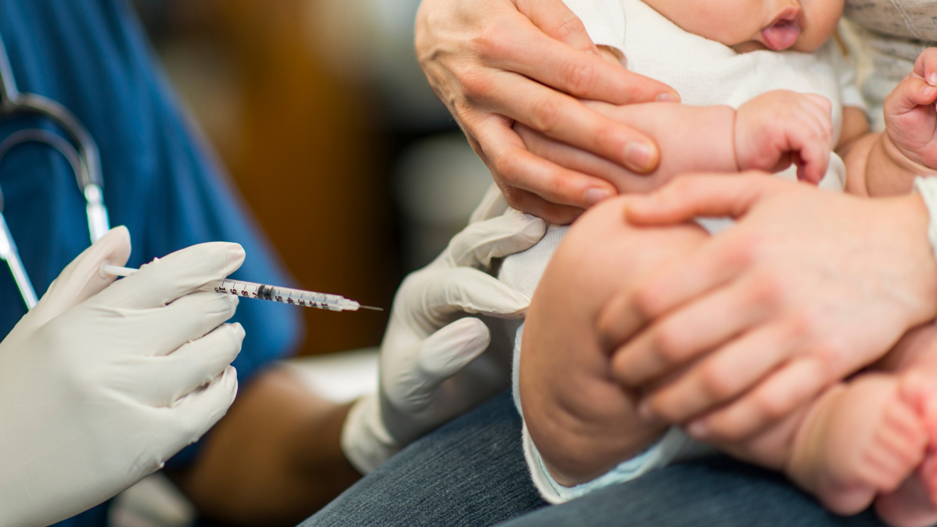 Practice nurse giving an adult patient a flu vaccination in a bright clinic room
